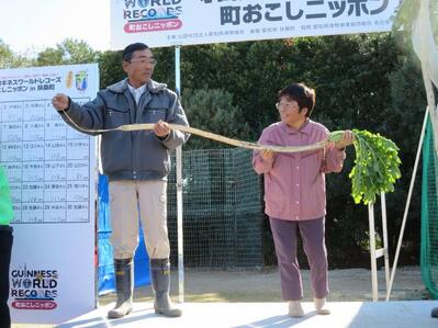 写真：ギネスに認定された守口大根を持つ後藤雅次さん、富恵さん夫妻
