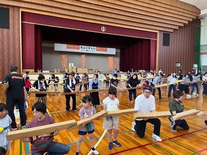 段ボールを使ってボールを横の人へ渡している写真